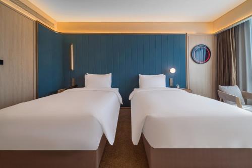 Postel nebo postele na pokoji v ubytování Yangjiang Jiangcheng Jinshang Road Orange Crystal Hotel