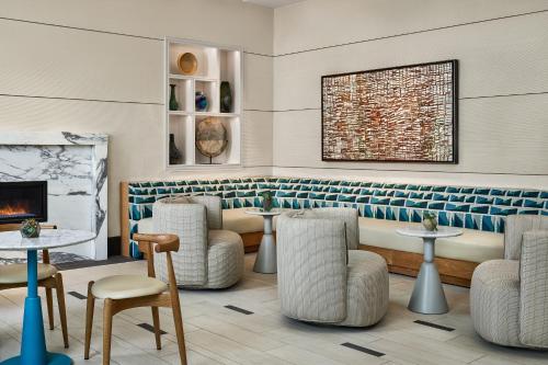 a lobby with a fireplace and chairs and a couch at The Highland Dallas, Curio Collection by Hilton in Dallas