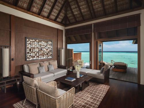 a living room with a couch and a table at Conrad Maldives Rangali Island in Mandhoo