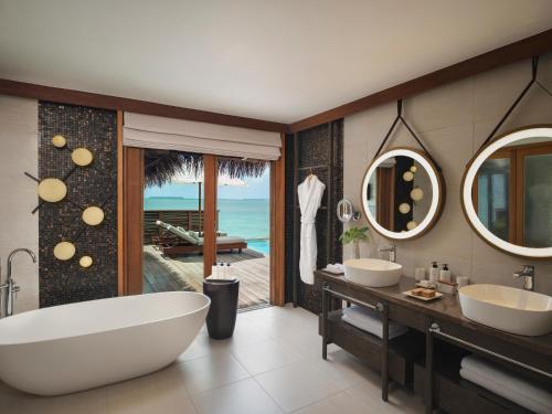a bathroom with two sinks and a bath tub at Conrad Maldives Rangali Island in Mandhoo