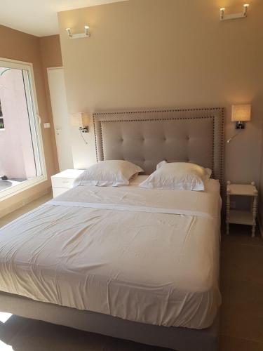 une chambre avec un grand lit blanc avec une fenêtre dans l'établissement Villa avec piscine proche des plages, à La Croix-Valmer