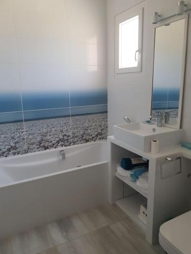 une salle de bain blanche avec une baignoire et un lavabo dans l'établissement Villa avec piscine proche des plages, à La Croix-Valmer