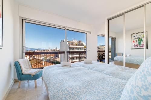 une chambre avec deux lits et une grande fenêtre dans l'établissement Skyline 2-bedroom flat with Epic Views - Roi Chevalier, à Antibes