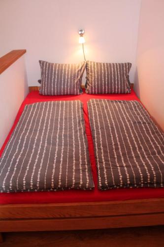 a bed with brown and white sheets and pillows at Penzion Podzámčí in Jaroslavice