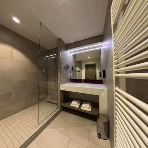 a bathroom with a shower and a sink and a mirror at Katholisch-Soziales Institut in Siegburg