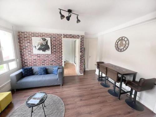 un salon avec un canapé et une table dans l'établissement Le Dumont - Apt 4 Prs, 3 Ch, Quartier Wilson, à Dijon