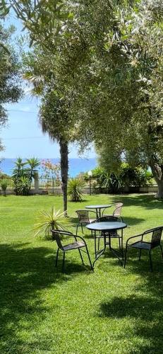 a group of picnic tables and benches in a park at MOLA PAPAYA STUDIOS in Mola Kalyva