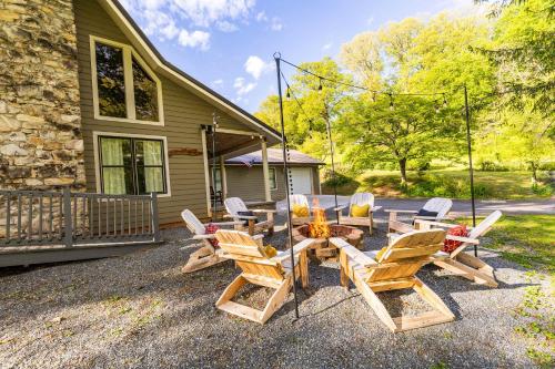 eine Gruppe von Stühlen und einem Tisch vor einem Haus in der Unterkunft Cozy Family Getaway w Games Hot Tub & Fire Pit in Bryson City