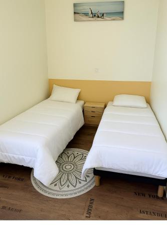 deux lits côte à côte dans une pièce dans l'établissement Maison souplex avec patio aux sables - 4 personnes, à Les Sables-dʼOlonne