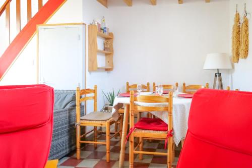 une salle à manger avec une table et des chaises rouges dans l'établissement Maison souplex avec patio aux sables - 4 personnes, à Les Sables-dʼOlonne