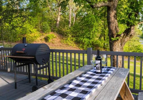 ブライソン・シティにあるCozy Family Getaway w Games Hot Tub & Fire Pitのデッキのピクニックテーブルの上のグリル