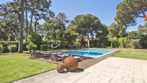 a swimming pool with a statue next to a yard at The Olive Villa Cascais Vive el lujo sereno entre pinares junto al Atlántico 5 minutos de la playa andando in Cascais