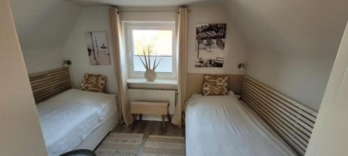 a small bedroom with two beds and a window at Büsumhaus Birgit in Büsum