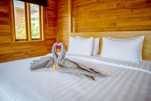 a bedroom with a bed with two towels on it at Taman Swarga Villa Resort & Spa Sidemen in Sidemen