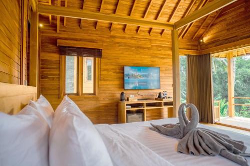 a bedroom with a bed with a television in it at Taman Swarga Villa Resort & Spa Sidemen in Sidemen