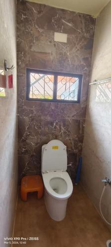 a small bathroom with a toilet with a window at Sukumar Villas in Nellore