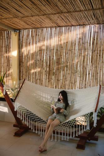 a woman sitting on a hammock in a room at Nhà Yên Homestay in Kinh Dinh