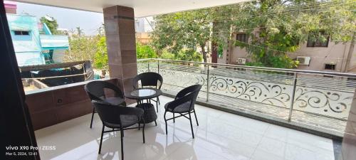 a patio with chairs and a table on a balcony at Sukumar Villas in Nellore