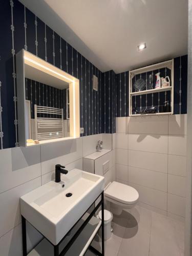 a bathroom with a white sink and a toilet at Lighthousestudio & Spa in Wangerooge