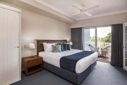 a hotel room with a bed and a balcony at Caves House Hotel & Apartments Yallingup in Yallingup
