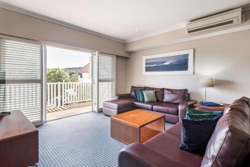 a living room with a couch and a table at Caves House Hotel & Apartments Yallingup in Yallingup