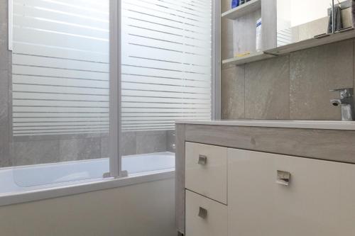 La salle de bains est pourvue d'une baignoire, d'un lavabo et d'une baignoire. dans l'établissement Maison à étage avec cour et garage les Sables - 4 personnes, à Les Sables-dʼOlonne