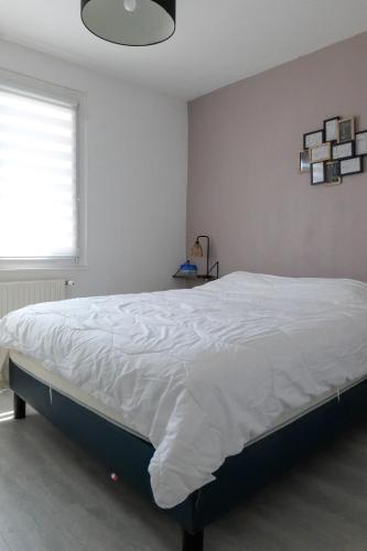 - un lit blanc dans une chambre avec fenêtre dans l'établissement Maison à étage avec cour et garage les Sables - 4 personnes, à Les Sables-dʼOlonne