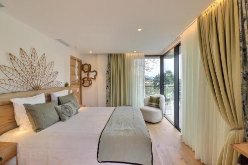 a bedroom with a large bed and a large window at LA BASTIDE DES CULS-ROUSSET in Marseille