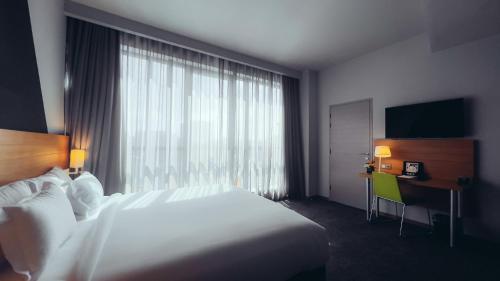 a hotel room with a bed and a desk and a window at ONOMO Hotel Casablanca City Center in Casablanca