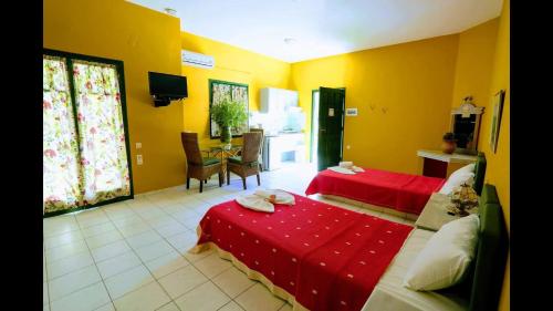 a hotel room with two beds and a dining room at Aquarius Apartments "by Checkin" in Agia Pelagia
