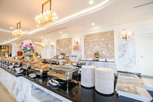 a buffet in a restaurant with plates and chandeliers at LK Grand Empire in Pattaya South