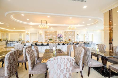 a dining room with a long table and chairs at LK Grand Empire in Pattaya South