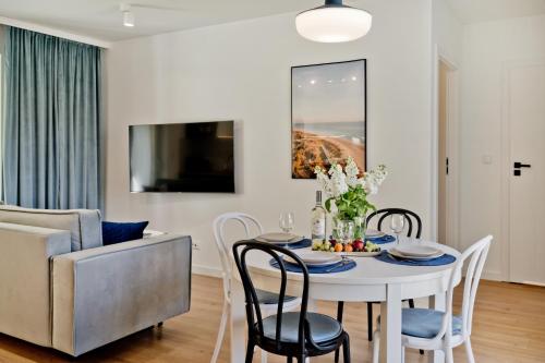 a dining room with a table and chairs and a couch at Casa Baia BlueApart Hel in Hel