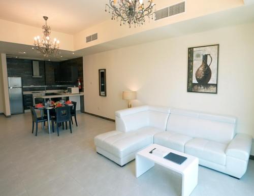 a living room with a white couch and a table at Al Manzil Hotel Bahrain in Juffair