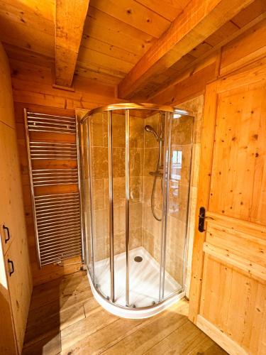 une douche à l'italienne dans une pièce en bois dans l'établissement Chalet St Bernard, à Saint-Jean-dʼAulps