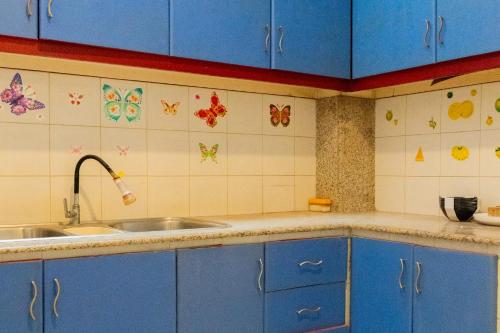 a kitchen with blue cabinets and a sink at Behomy Metropolim in Jakarta