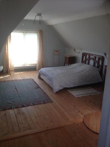 ヴィレルヴィルにあるLes Grands Houxのベッドルーム1室(ベッド1台、大きな窓付)
