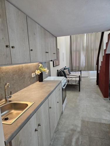 uma cozinha com um lavatório e uma sala de estar em Porto Castello em Fira