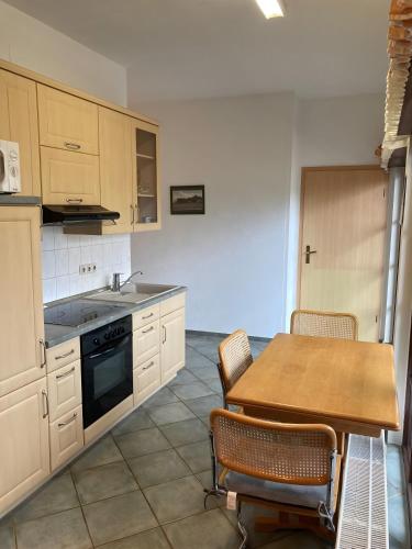 a kitchen with a wooden table and a table and chairs at Ferienwohnungen am Louisenteich in Frauendorf