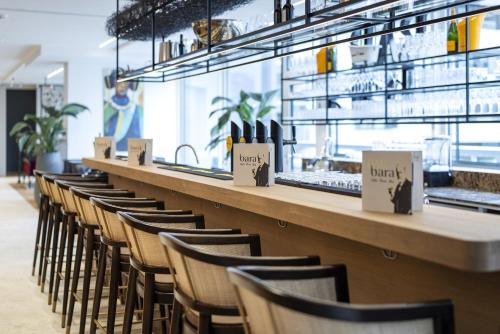 a row of chairs at a counter in a restaurant at ARCOTEL AQ Wien in Vienna