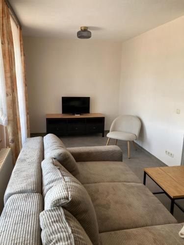 a living room with a couch and a television at Ferienwohnungen am Louisenteich in Frauendorf