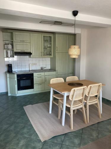 a kitchen with a wooden table and chairs at Ferienwohnungen am Louisenteich in Frauendorf