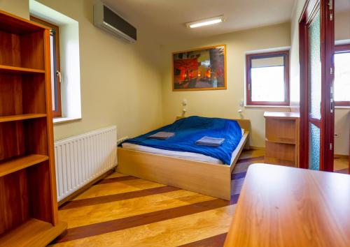 a small bedroom with a bed and a table at Sunset Suites Füred in Balatonfüred