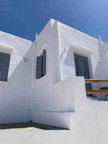 a white building with black doors and windows at Cycladic Lodge Sifnos in Apollonia