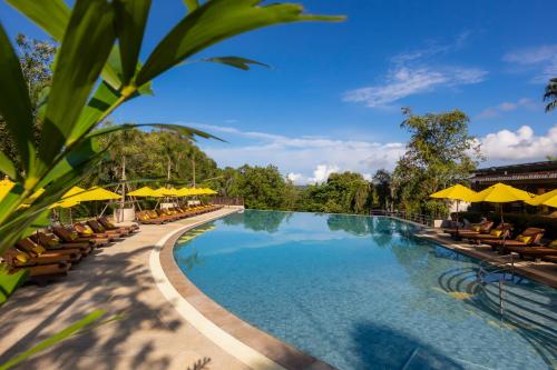 a swimming pool with chairs and umbrellas at a resort at Pakasai Resort in Ao Nang Beach