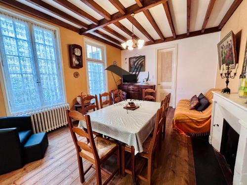 - une salle à manger avec une table, des chaises et un piano dans l'établissement Gite de Mali - De plain pied à deux pas du centre, à Rochefort