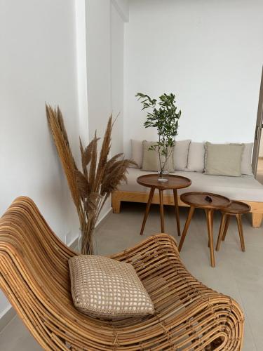 a living room with a rattan couch and tables at Sea Bliss Adults Only in Parga