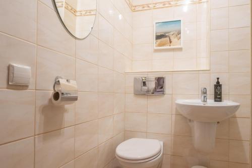 a bathroom with a toilet and a sink at Naptun Old Town by Alqueen Apartments in Gdańsk