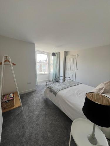 ein Schlafzimmer mit einem Bett und einem Stuhl und einem Fenster in der Unterkunft roof tops apartment in Ilfracombe