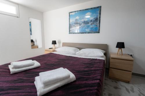 a bedroom with a large bed with two towels on it at Villa PAPADATES ARTEMIS in Barbaliáki